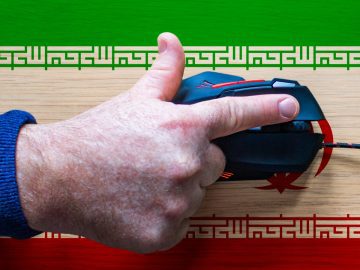 Iranian hackers behind retaliatory cyberattacks on US orgs Hand on keyboard with an Iranian flag background