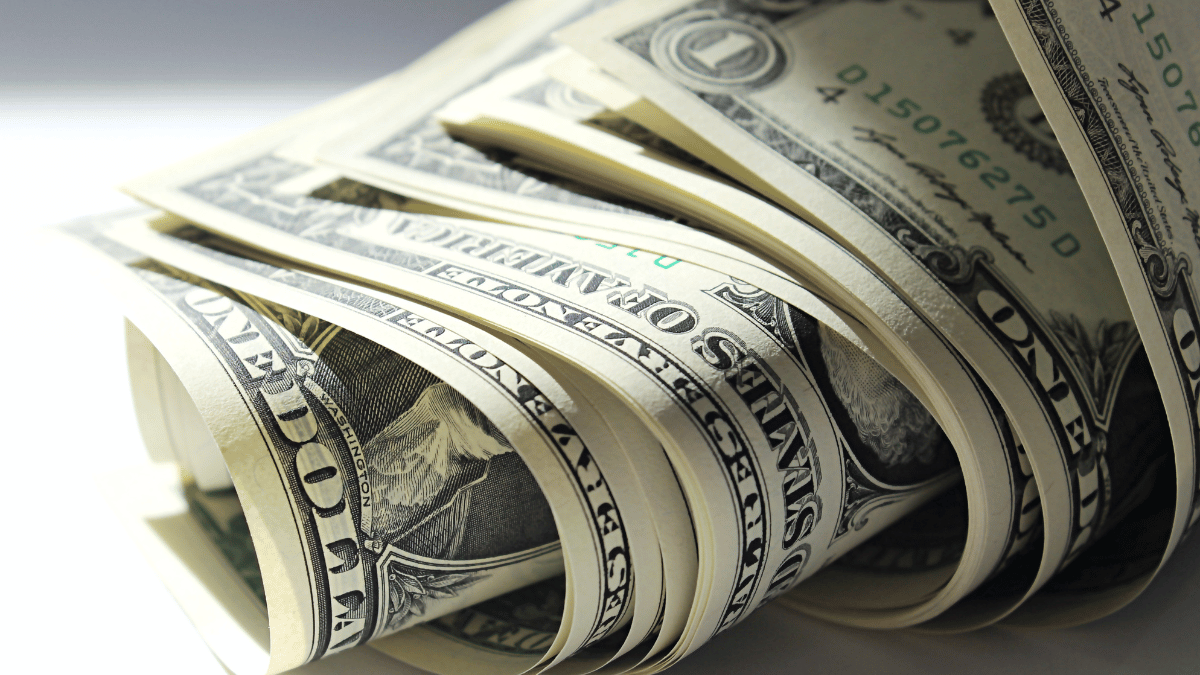 The “free money” trap: How scammers exploit financial anxiety Rolled up US dollar bills