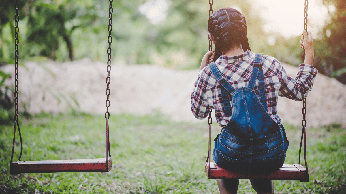Child on a swing next to an empty swing