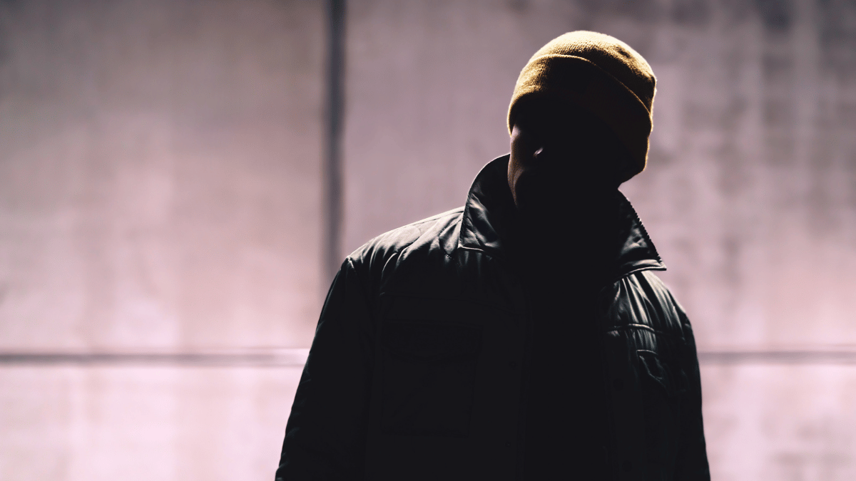 Man in the dark wearing a hat