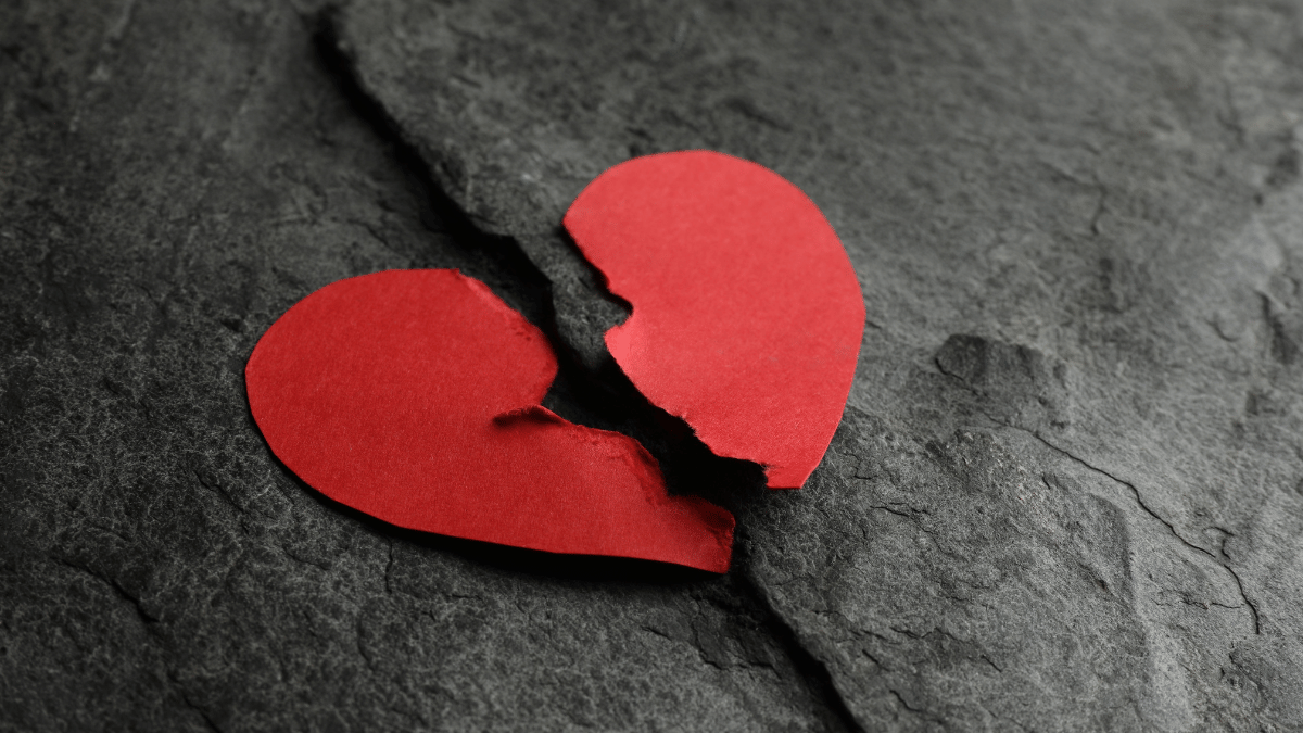 A heart shaped piece of paper that has been ripped down the middle