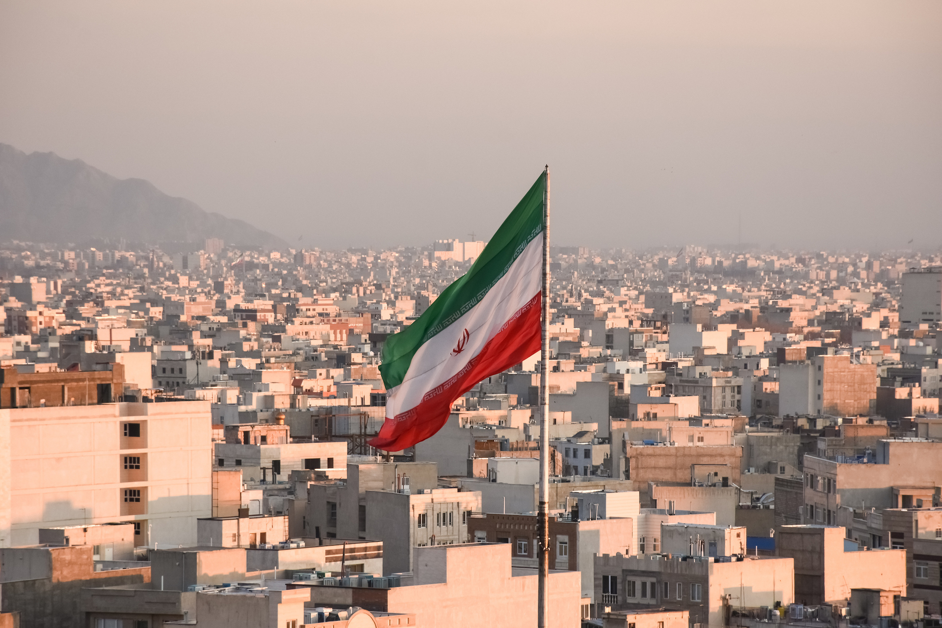 Iran’s financial sector takes another hit as largest crypto exchange is targeted Iranian flag waving with cityscape on background in Tehran, Iran. (Sir Francis Canker Photography/Getty Images)