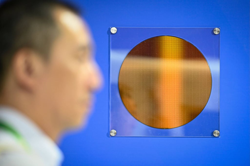 A man walks past a silicon wafer display at Micron Technology’s booth during the China International Supply Chain Expo in Beijing on July 16, 2025. Photo: AFP