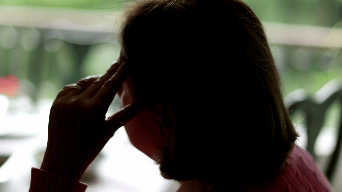 Back of woman with her head in her hand
