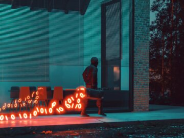 A figure walking with a glowing trail of binary code emanating from a case, symbolizing stolen data. (Getty Images Plus)