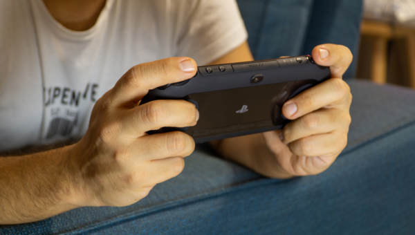 Close up of a man's hands playing the PlayStation Vita