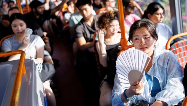 Passengers use fans to cool down on a TfL bus during a heatwave in East London on June 24. Photo: EPA