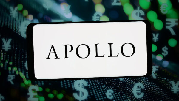 The logo of Apollo Global Management is displayed on a smartphone in front of abstract background. (Photo Illustration by Timon Schneider/Getty Images)