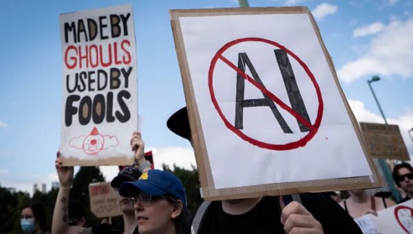 A sign opposed to AI is held during a protest against AI data centers in Vancouver, British Columbia, Canada, on Saturday, June 27, 2026. Canadians aren't universally sold on building sovereign compute, with early signs of protest against AI server farms in British Columbia and Manitoba. Photographer: Ethan Cairns/Bloomberg via Getty Images