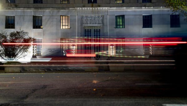 Light trails from a passing vehicle are seen in front of the Department of Justice building in Washington on November 21, 2021. (Stefani Reynolds for The Washington Post via Getty Images)